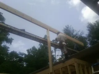 Carpenter setting a ridge beam over a new addition frame — Ice Dam Removal by Roofing Brothers in Stone Creek