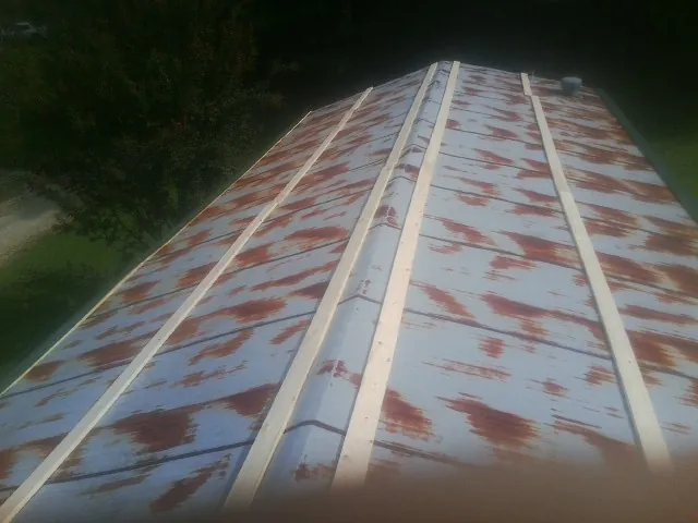 Rusted metal roof panels with new wood purlins before replacement — Storm Damage Roof Repair in Stone Creek by Roofing Brothers