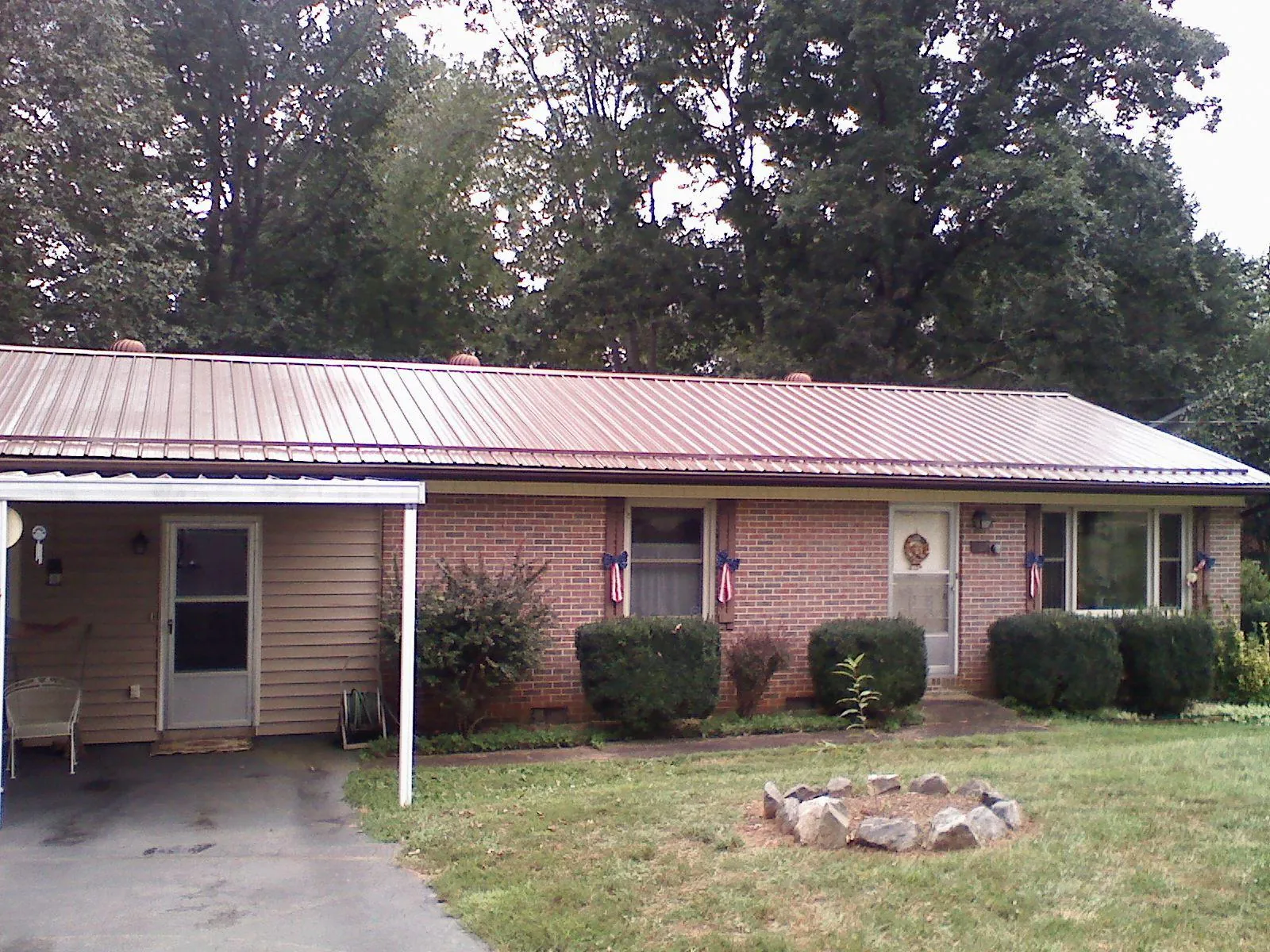 Bronze metal roof and carport on a brick ranch home — Roof Repair work by our crew in Stone Creek