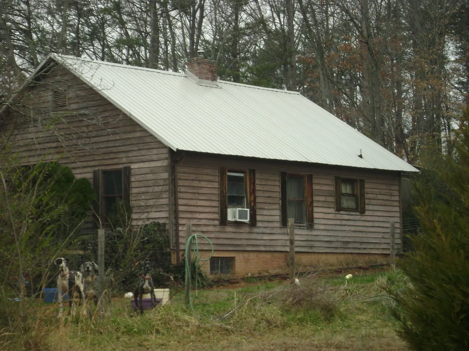 White metal roof on an old wood sided farmhouse, from a Metal Roof Installation job in Stone Creek